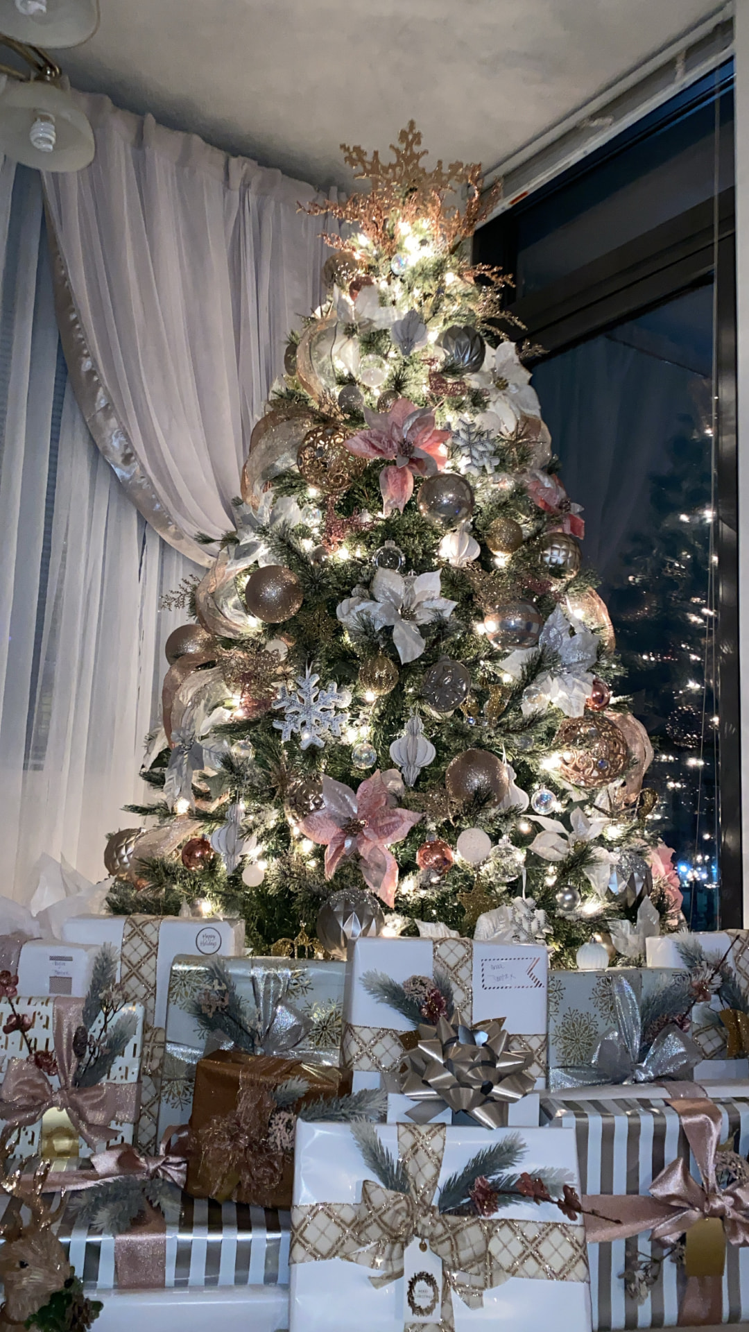 Designer Christmas tree styled in silver, champagne, blush, and gold with coordinated wrapped gifts at the base